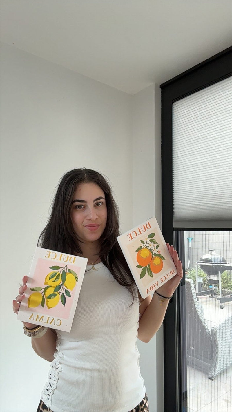 Holding two finished paint by numbers canvases