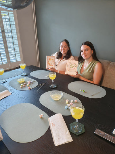 Two friends painting together at the kitchen table