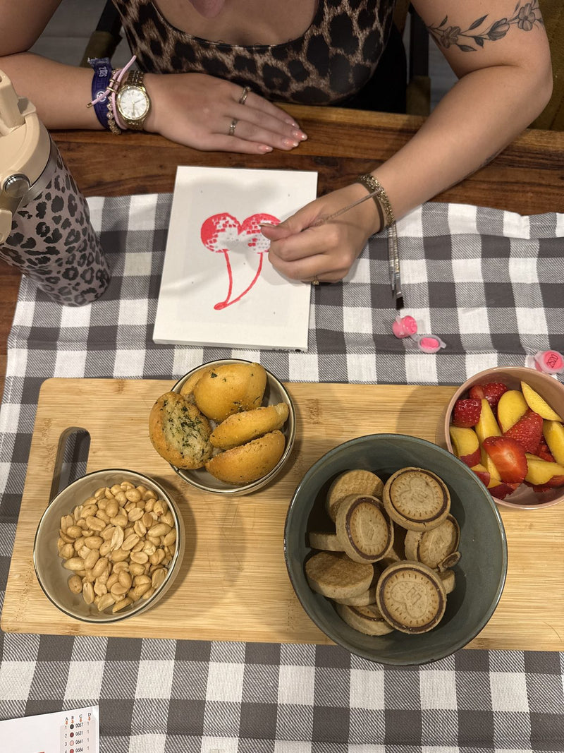 Painting a canvas at a table set with snacks