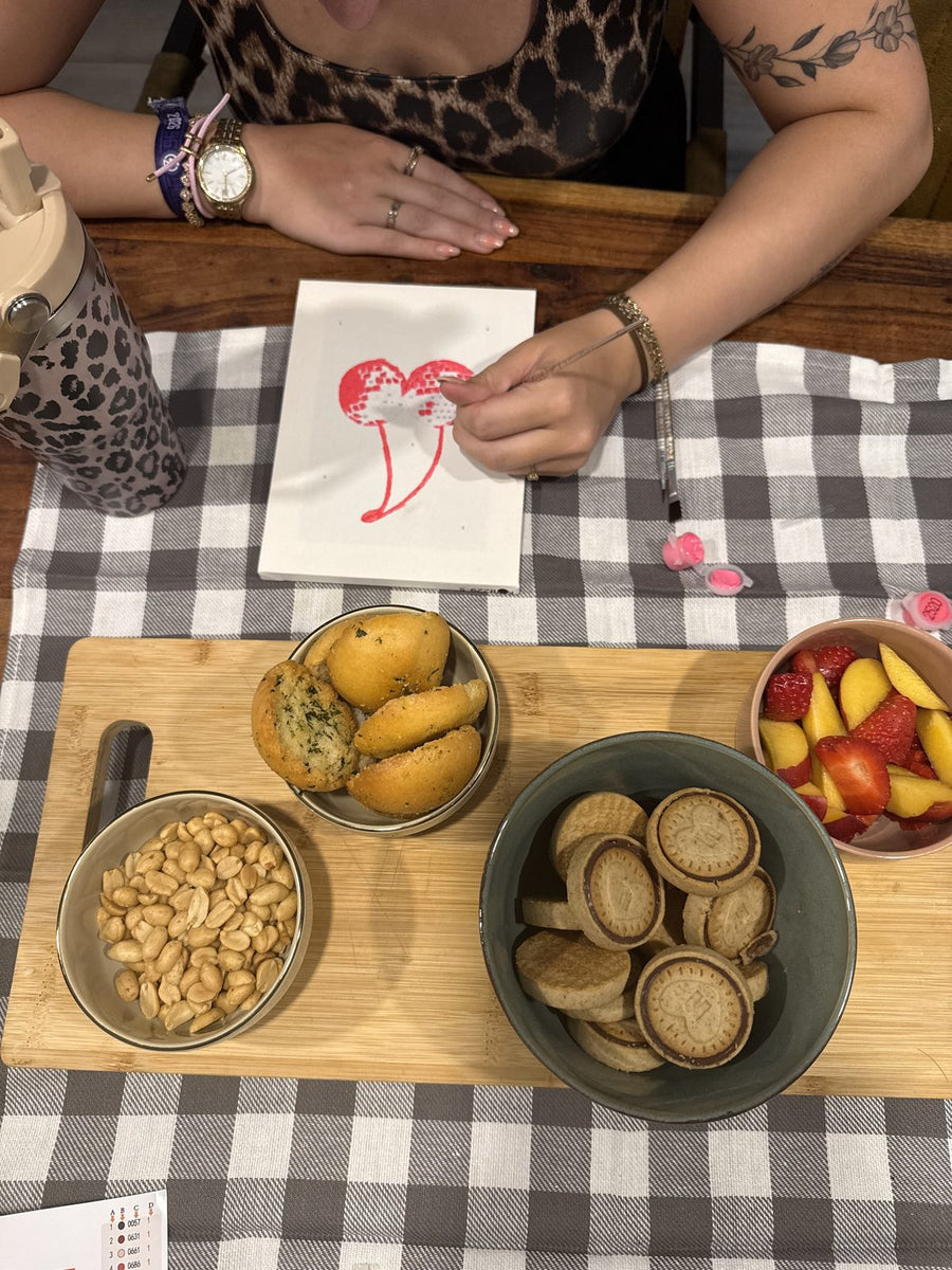 Painting a canvas at a table set with snacks