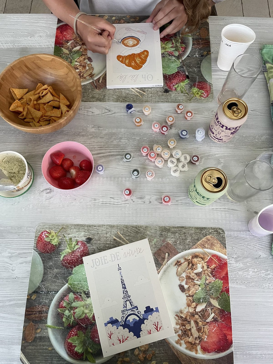 A group painting canvases around a brunch table