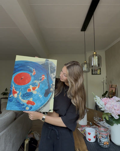Holding up a finished paint by numbers canvas
